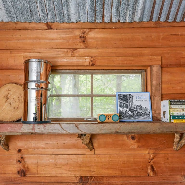 Travel Berkey sur une étagère à côté de la fenêtre d'une cabane en bois