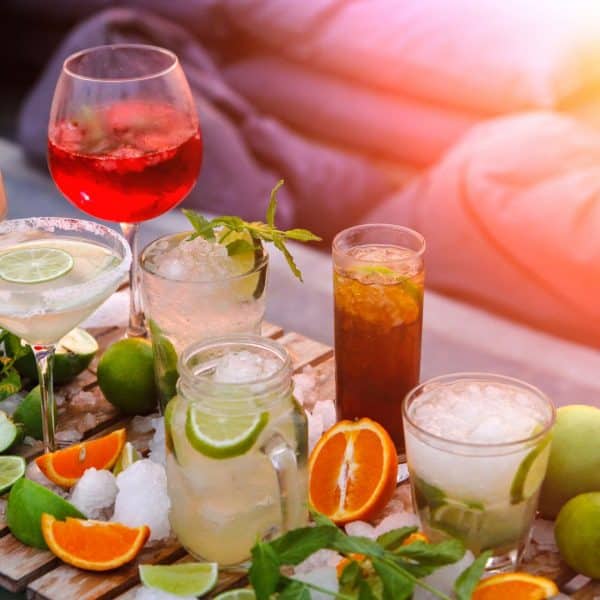 Divers Cocktails sur une table entourés des ingrédients pour les créer